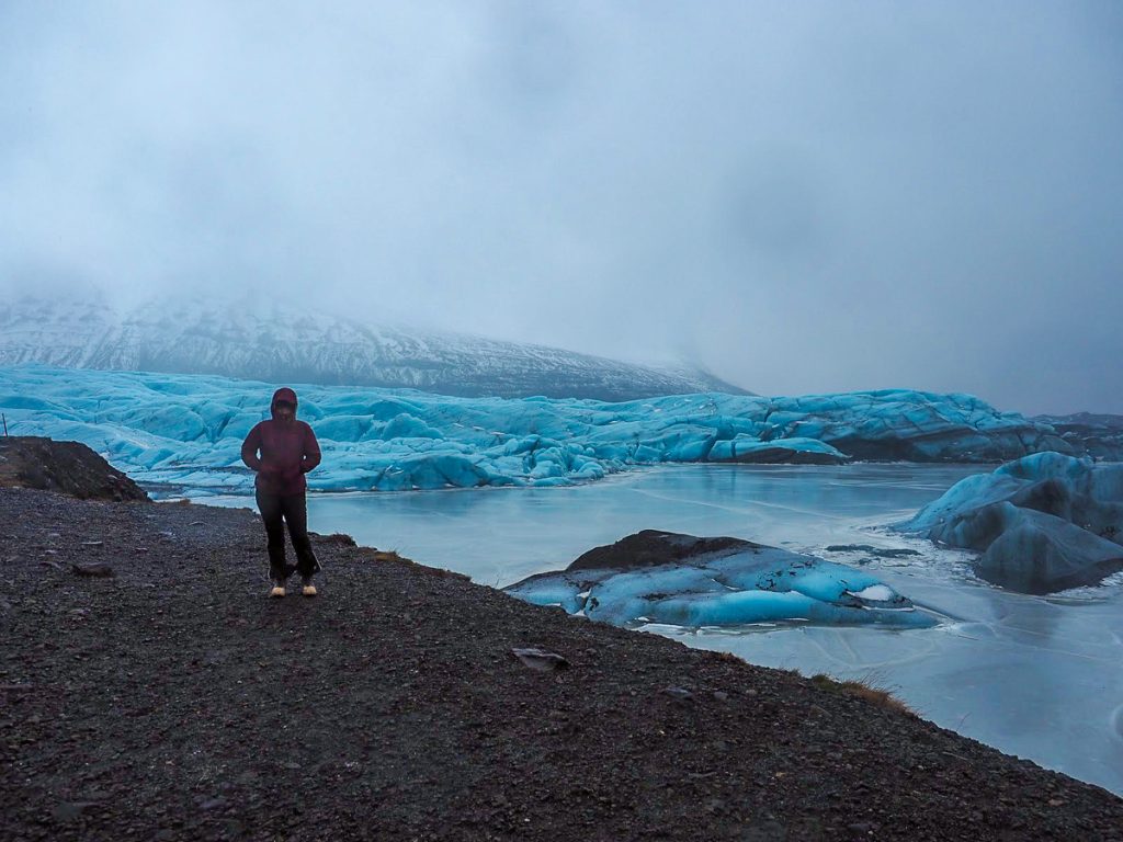A woman standing in front of glaciers at Jökulsárlón Glacier Lagoon