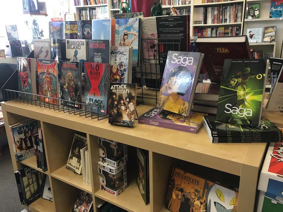 A display of comic books on wooden shelves in a store.