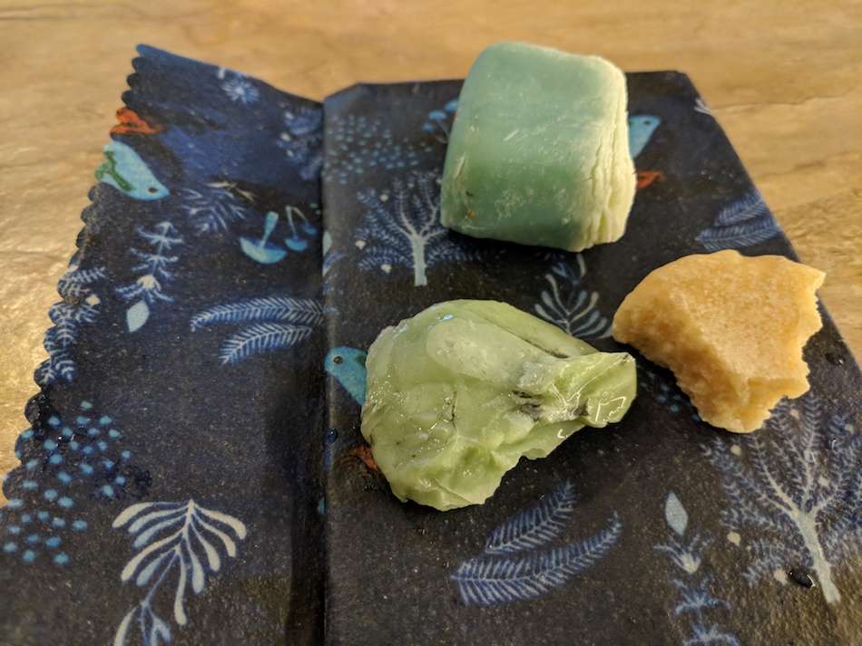 Some Lush sustainable bath products sitting on a patterned beeswax wrap.
