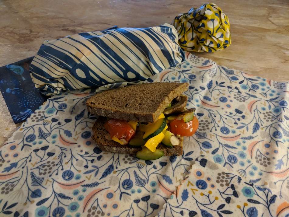 A vegetarian sandwich sitting on a patterned beeswax wrap.