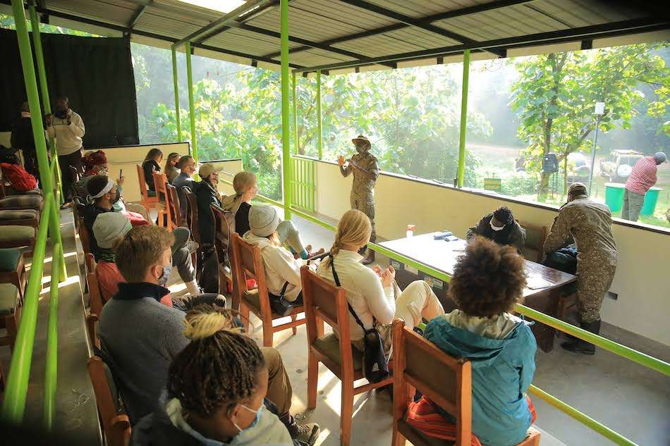 A group of travelers preparing for mountain gorilla trekking in a classroom setting