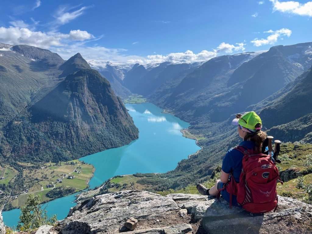 Woman on top of mountain over glacier lake in Norway