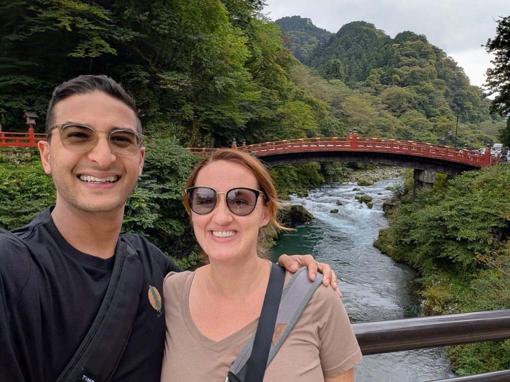 a man and woman in front of a bridge in Nikko National Park
