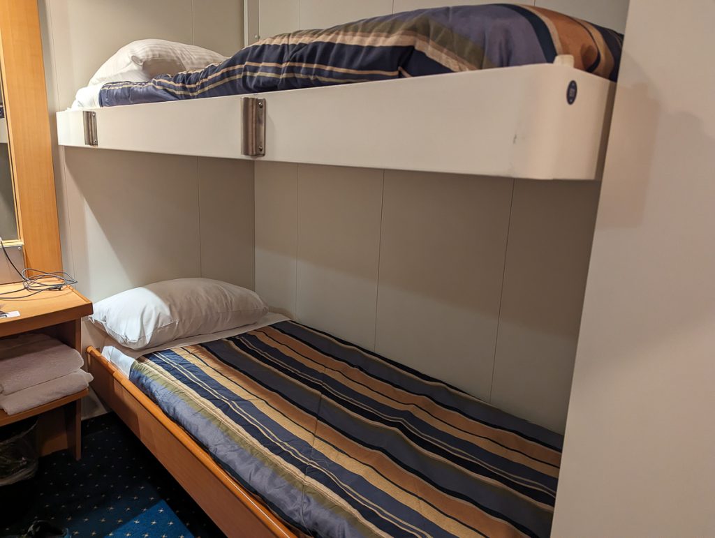 Two bunk beds with striped blankets on a BC Ferry.