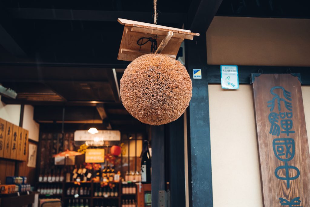 A close-up shot of a big cedar ball hanging above the doorway of a sake brewery in Takayama, Japan.