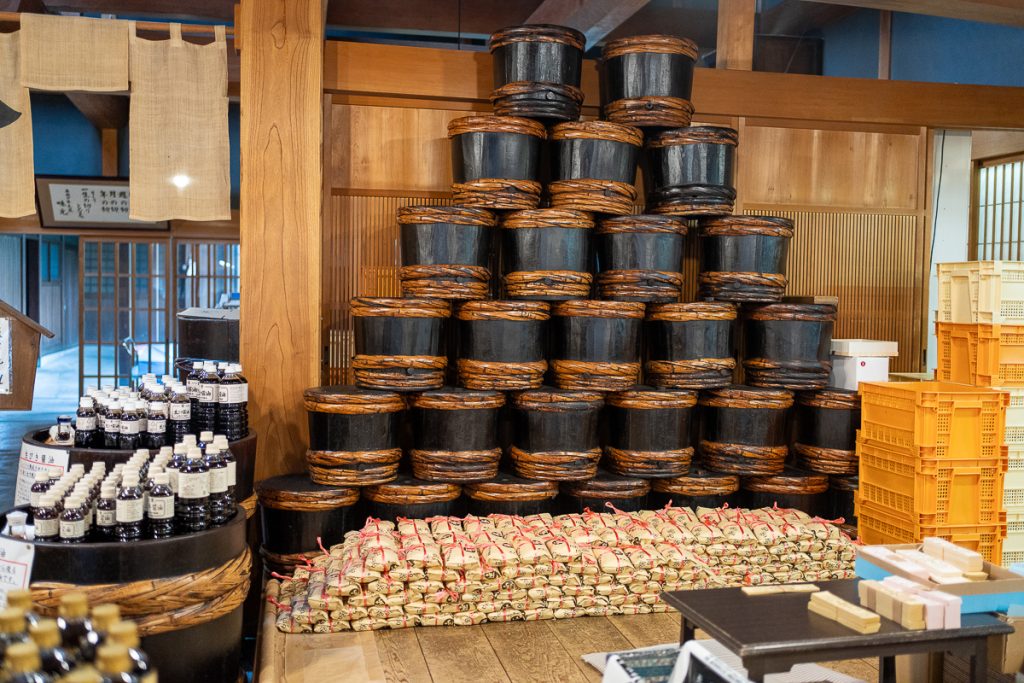 A shop display of barrels, sacks and bottles filled with miso and soy!
