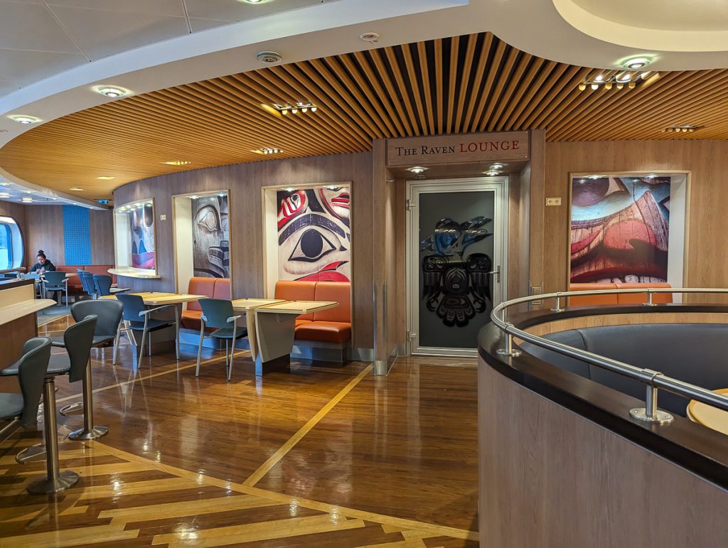 A lounge/bar area with glossy wooden floors, artwork and a sign saying "The Raven Lounge."