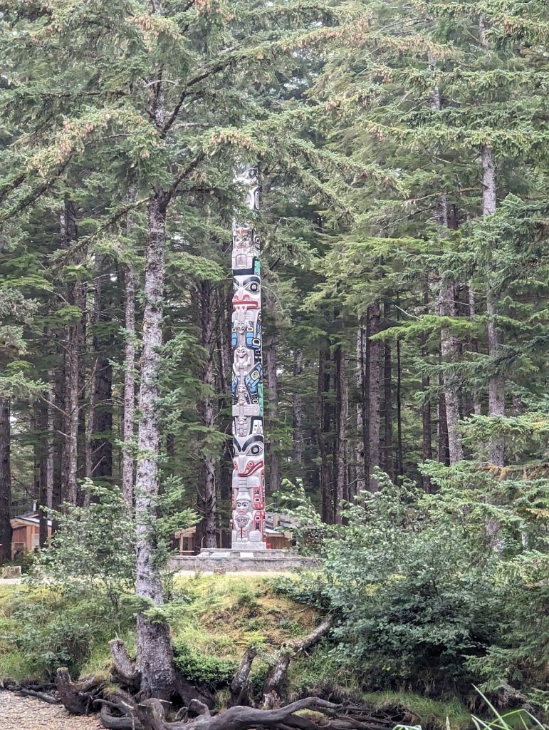 A Haida totem pole surrounded by pine trees.