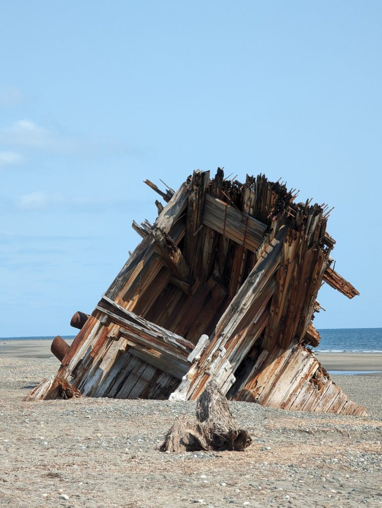 An old wooden WWII era ship called the Pesuta wrecked on the beach in Haida Gwaii