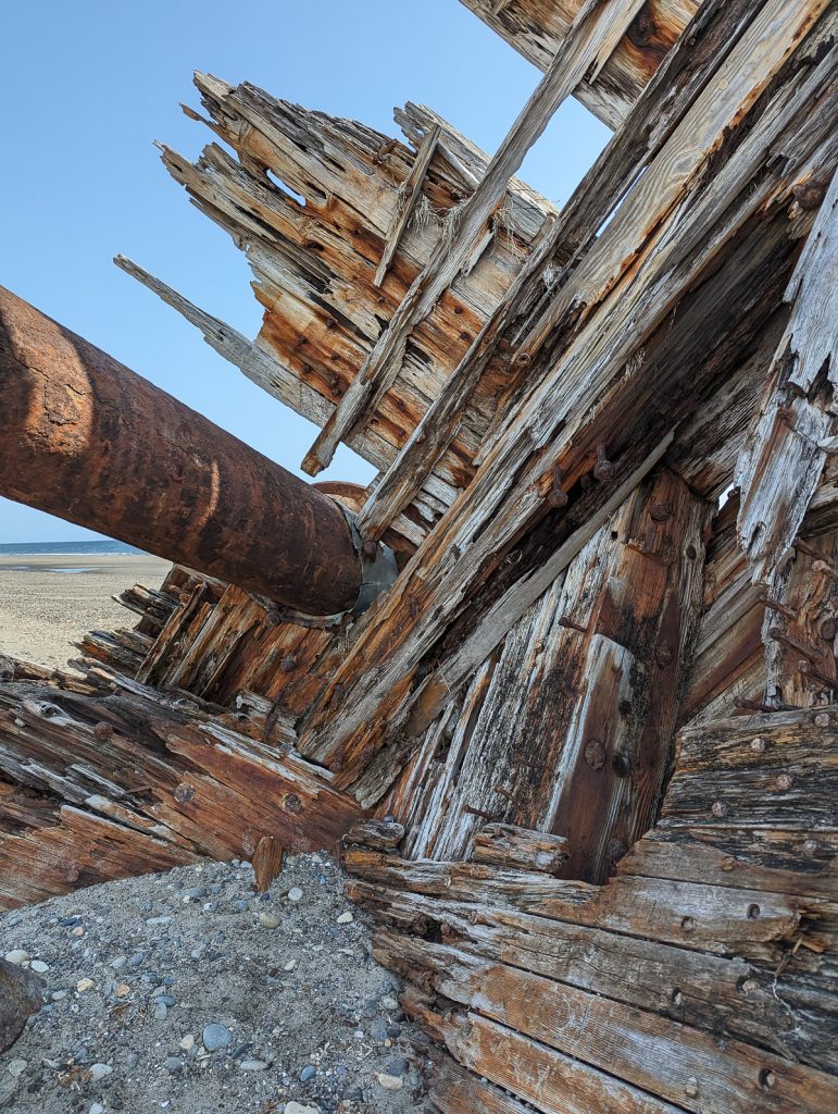 An old wooden WWII era ship called the Pesuta wrecked on the beach in Haida Gwaii