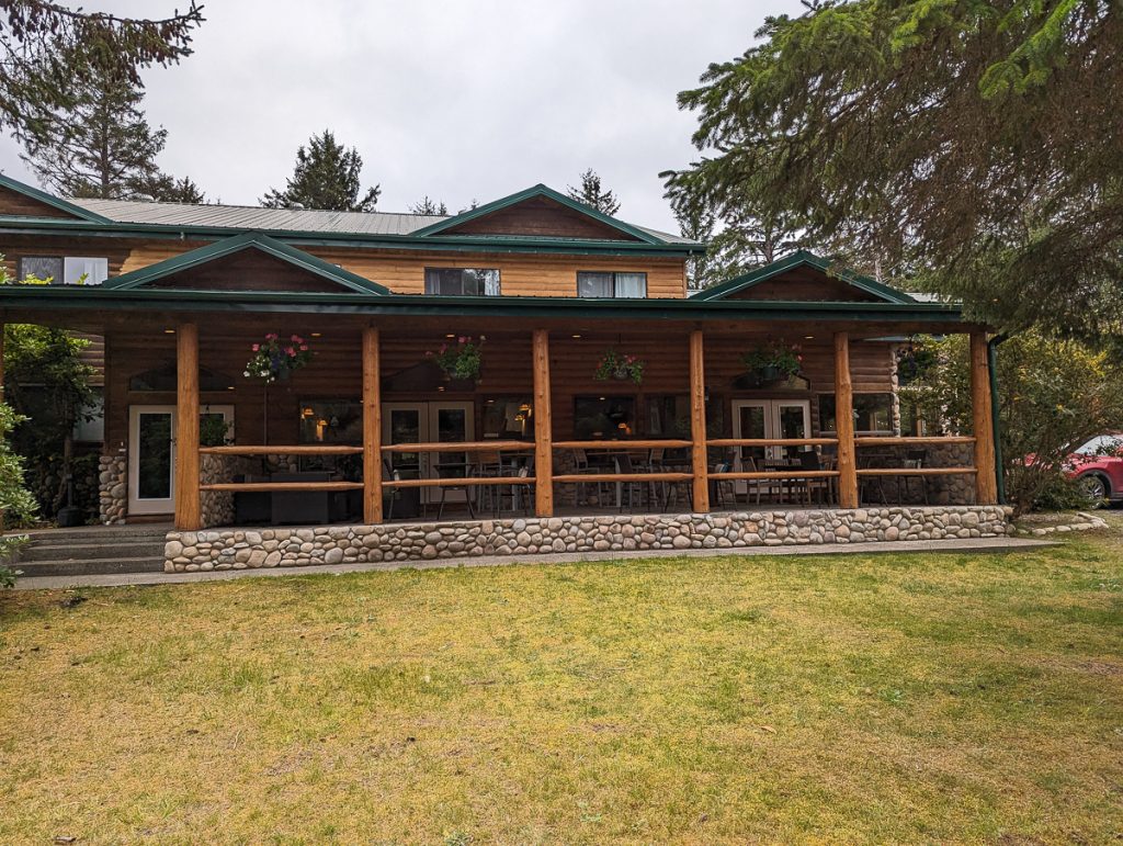 The main lodge building at Haida House, a wooden lodge with covered balcony and stone foundations.