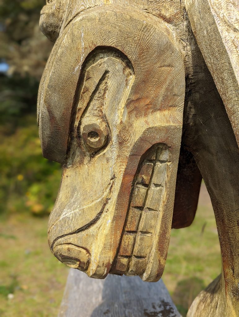 A close-up photo of an animal face carved from wood.