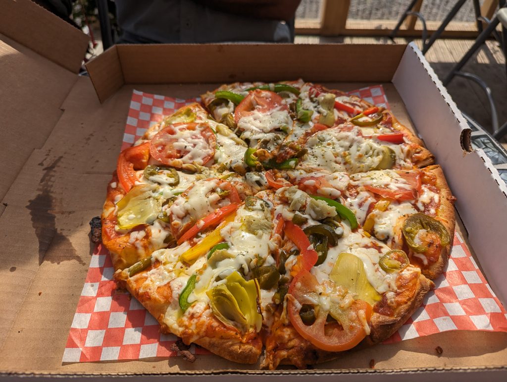 A close up of a vegetarian pizza in a cardboard pizza box.