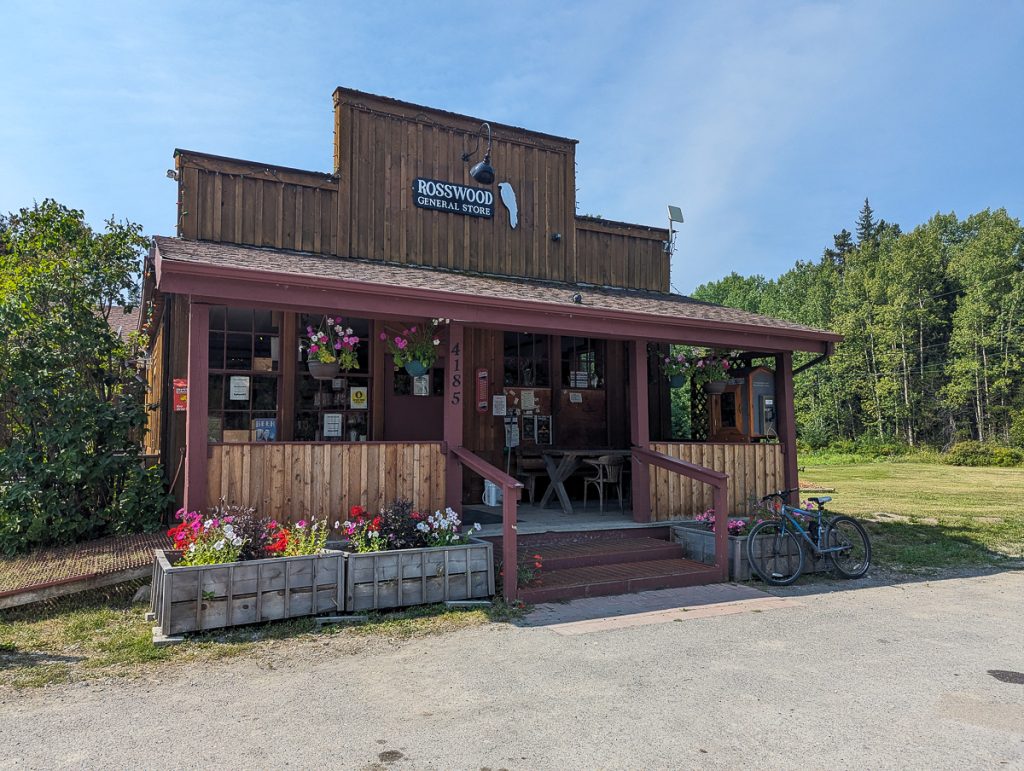 A small wooden building with a covered porch, and a sign saying "Rosswood General Store."