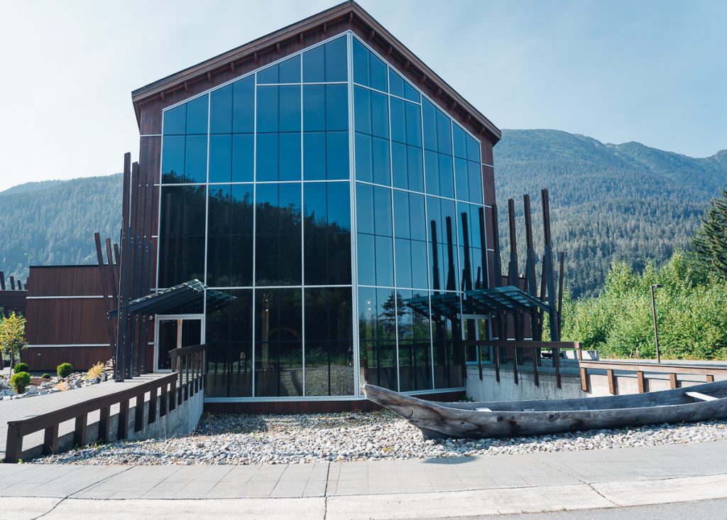 A tall wooden building with the entire front covered in glass windows.