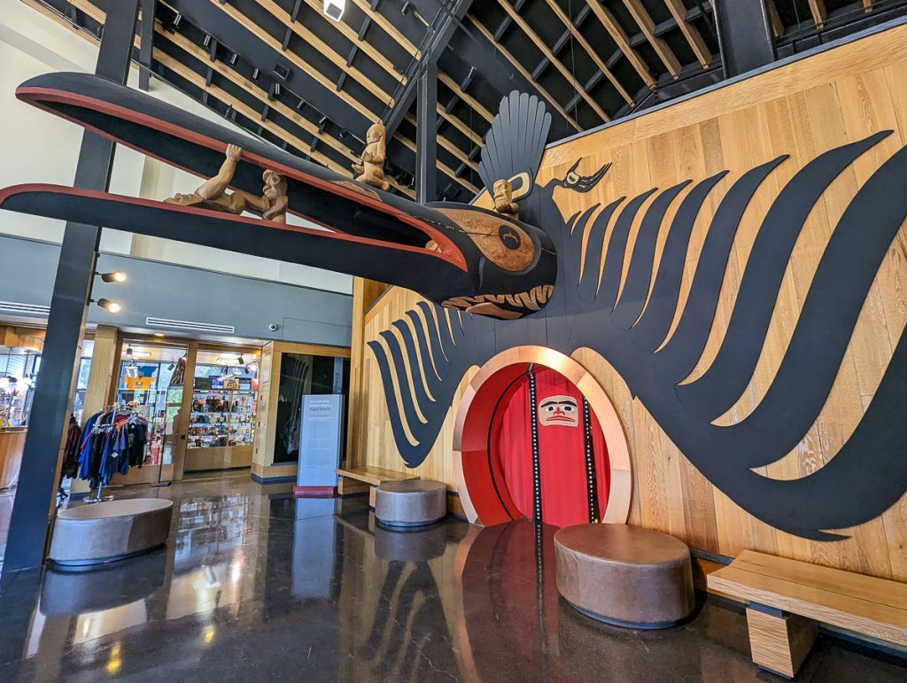 An interior room with a huge bird head sculpture above a door that's been painted to look like the bird's belly and wings on either side.