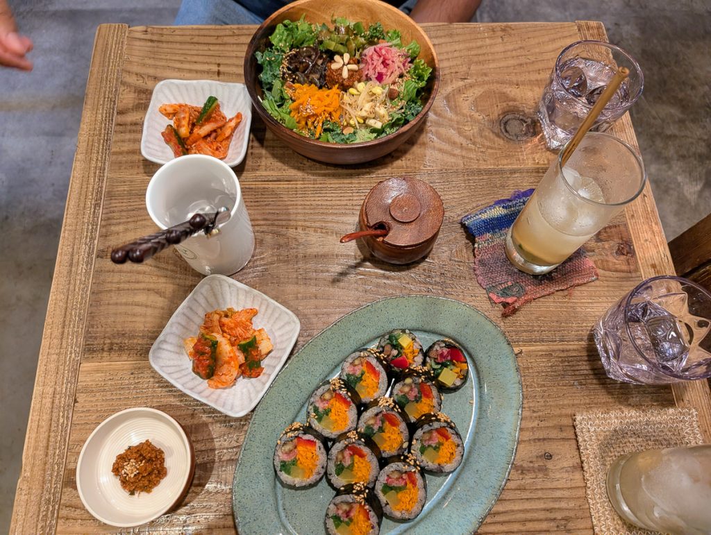 An above view photo of a table at a restaurant with a range of plates of vegan food and drinks.