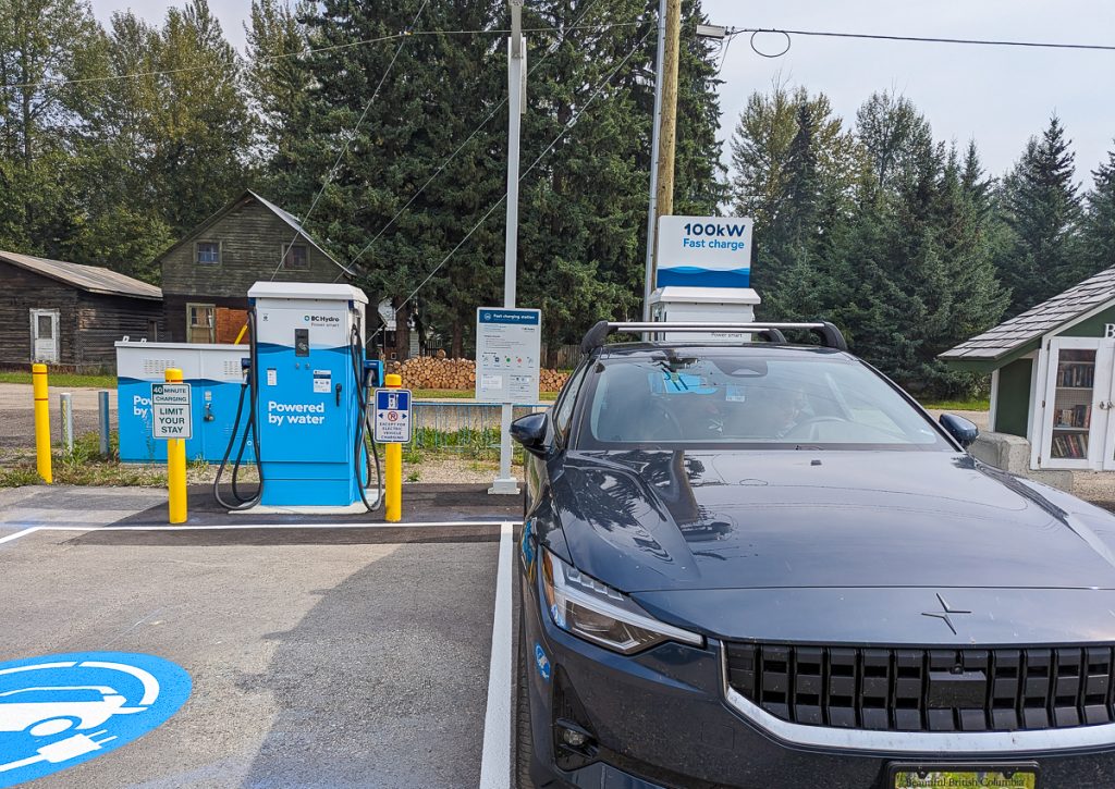 An electric vehicle parked in a charging bay next to a charging bay with no car in it.