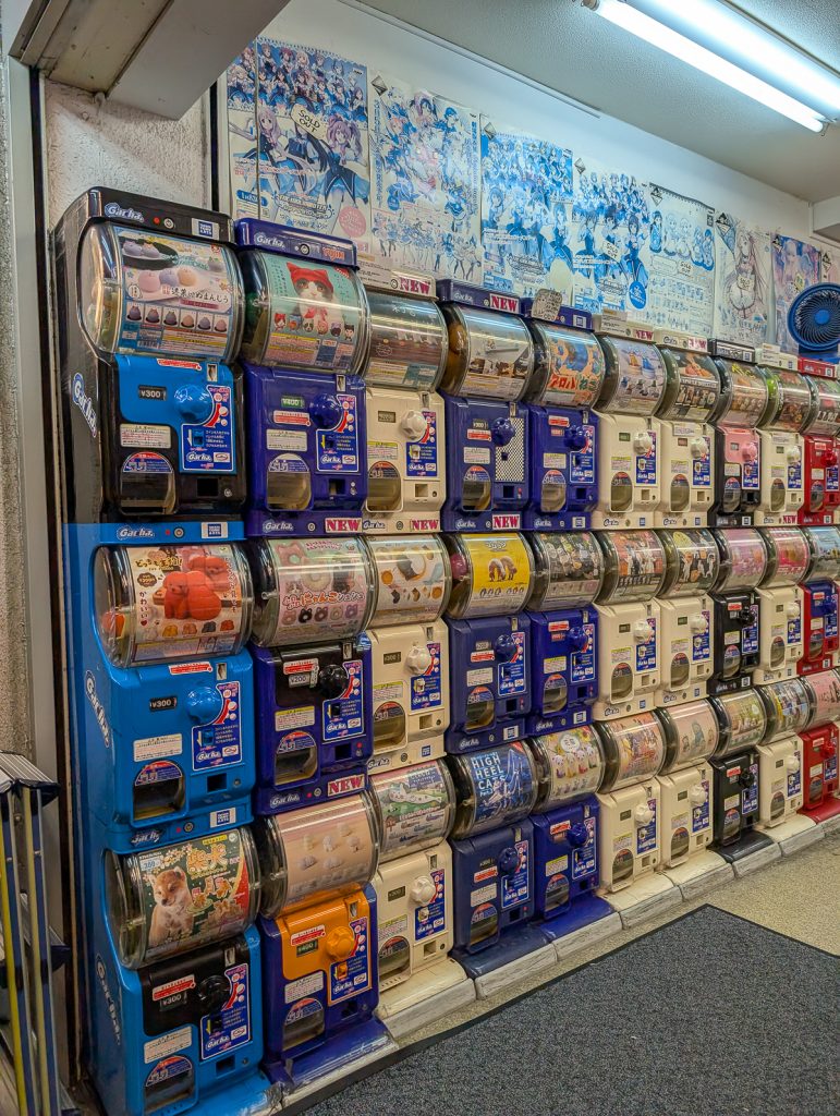 A wall of Japanese gachapon machines in a shop.