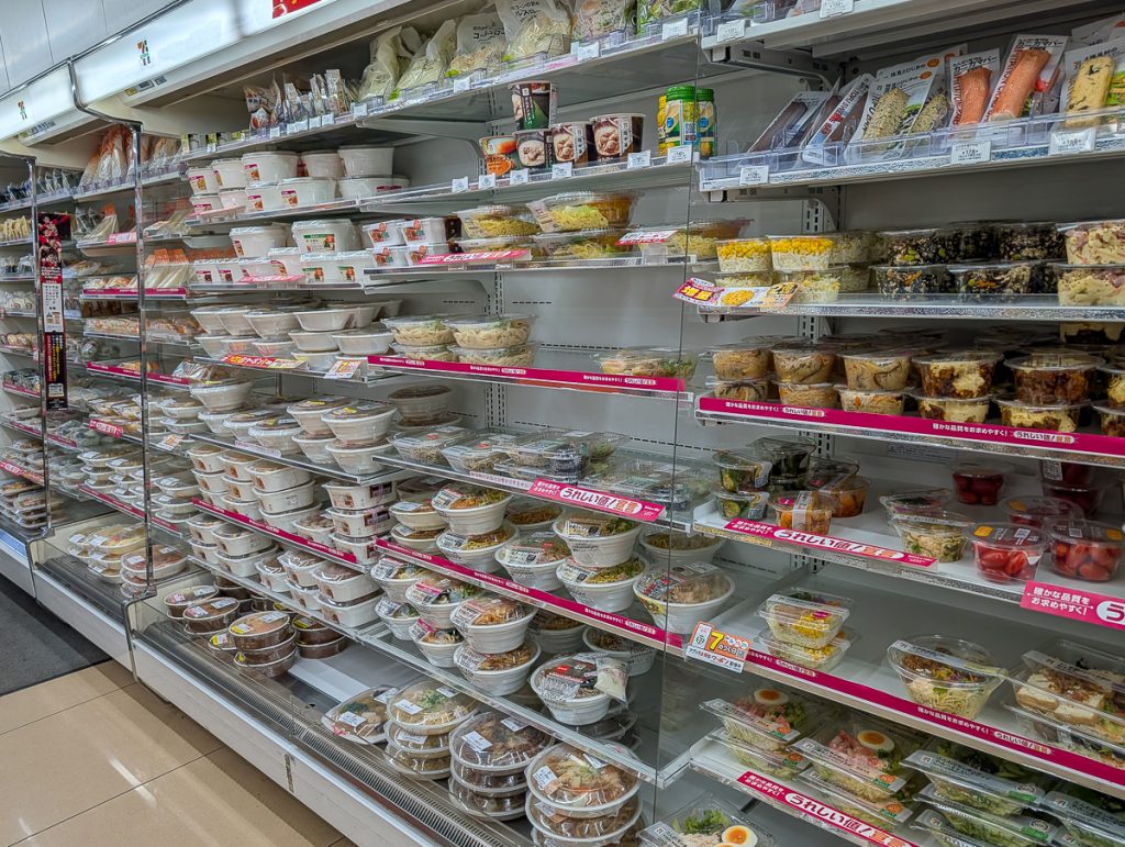 a wall of food items wrapped in single-use plastic containers in Japan