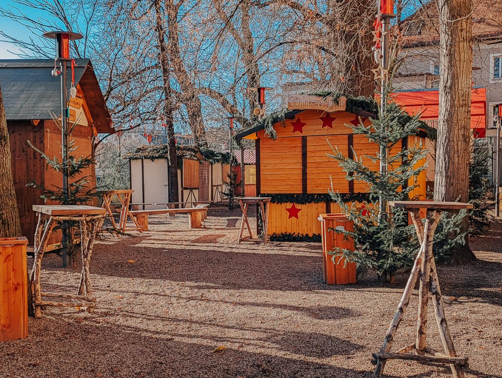Closed up wooden Christmas market booths on a sunny day.