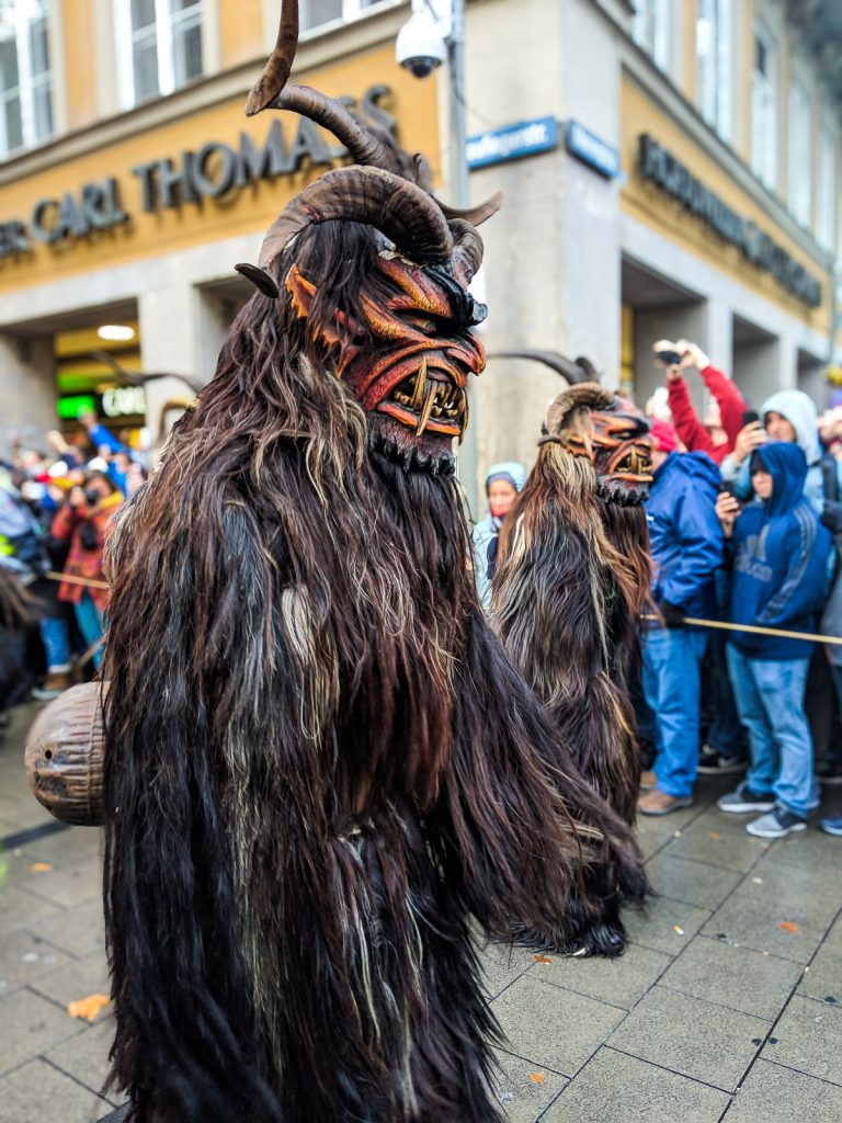 a devilish costumed person with horns and fur march in Munich's Krampus Run