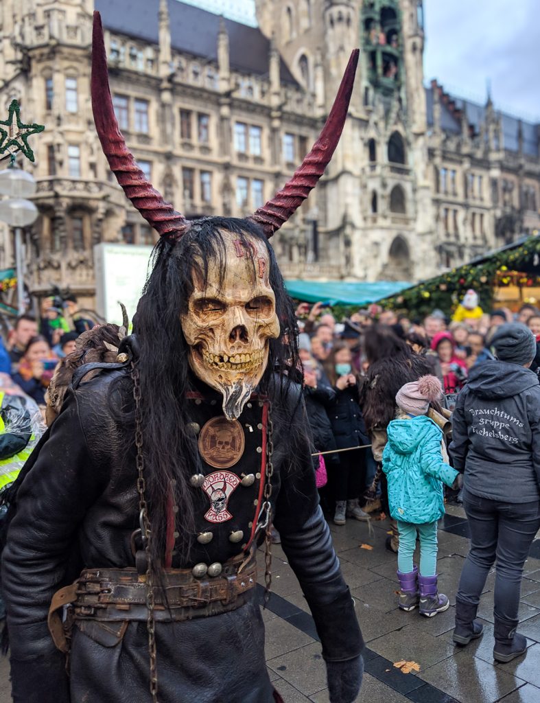 a costumed person horns and a devil-like mask depicting Krampus in Munich's Krampus Run