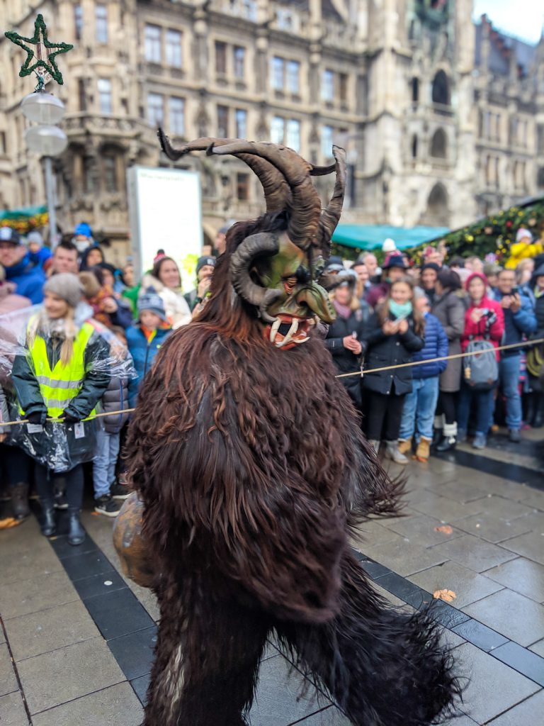 a costumed person with a mask, fur, and horns depicting Krampus in Munich's Krampus Run