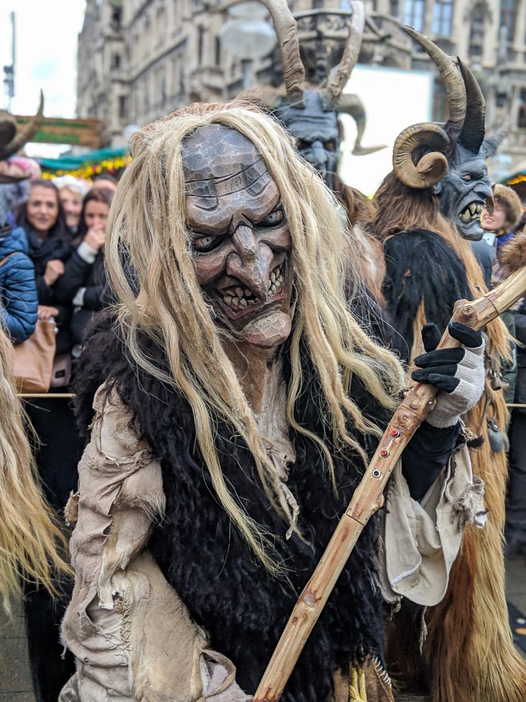 A devilish and horror masked person in a costume parade Krampus Run in Munich