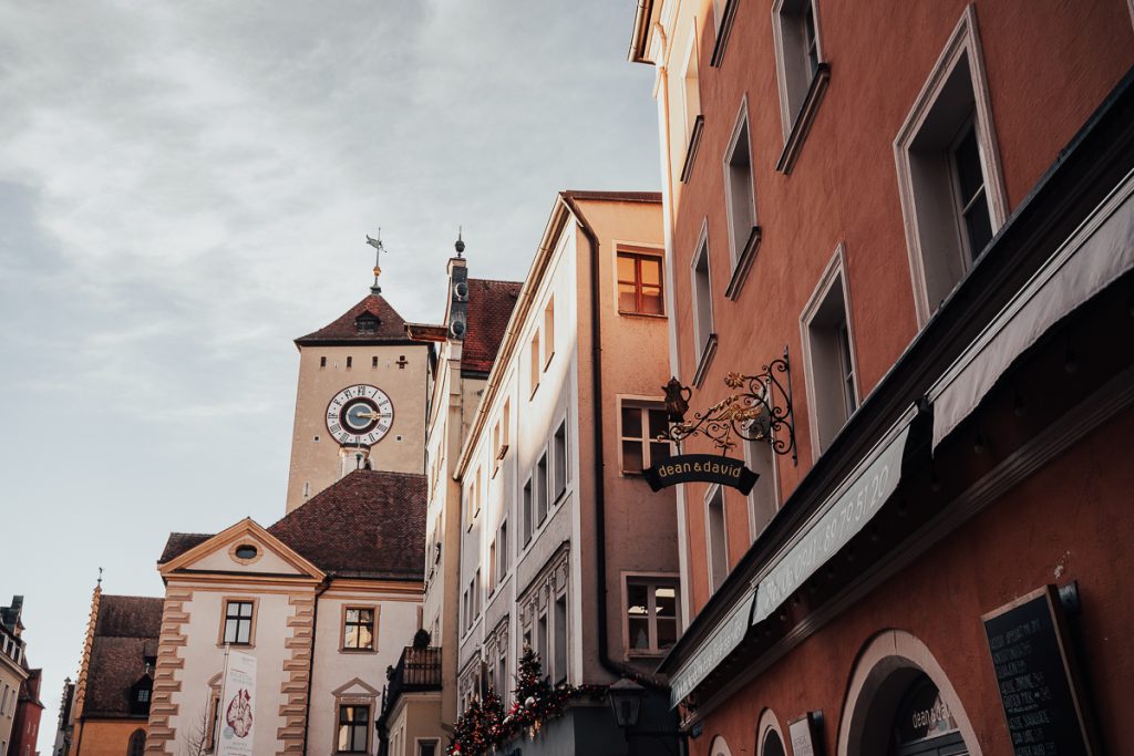 A close up of medieval buildings and a clock tower in Regensburg.
