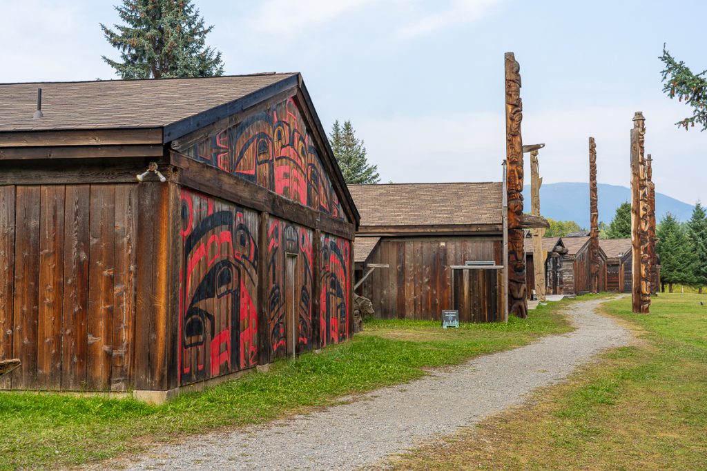 A group of traditional wooden buildings and totem poles at the Ksan Village in British Columbia.