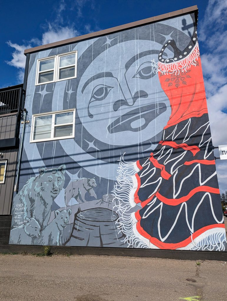 A beautiful Red Dress mural on the side of a building with a woman's face, bears and, of course, a red dress.