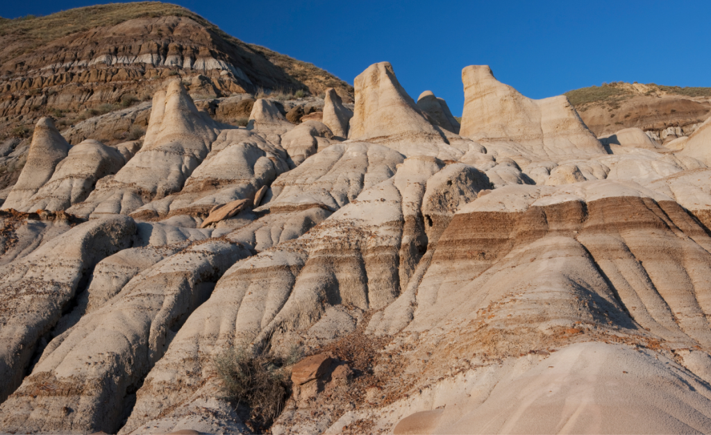 Pointed rock formations in front of a bright blue sky.