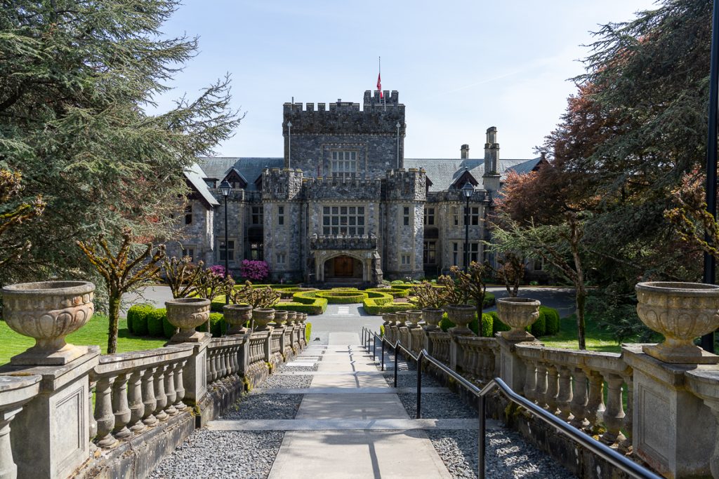 A small stone "castle" seen from stairs leading towards the entrance with a small hedge maze in front.