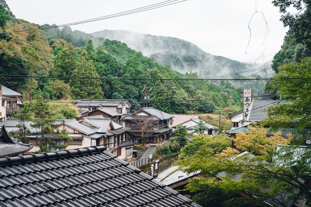 the rooftops of a Japanese village surrounded by forest on the Kumano Kodo
