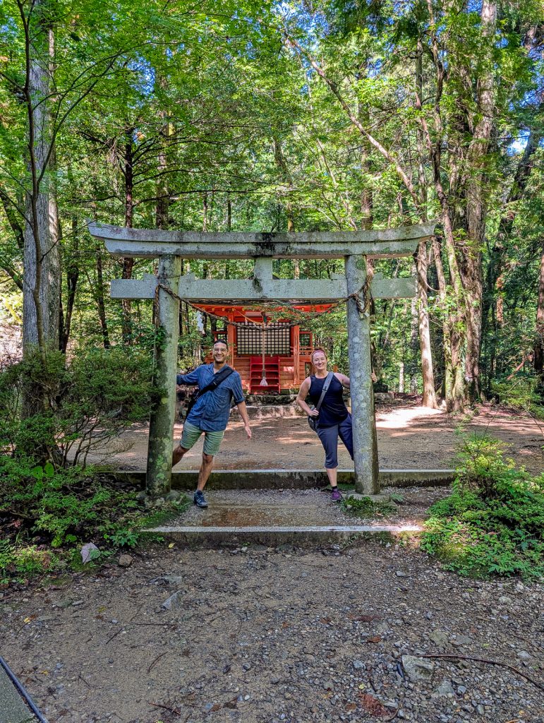 Susanna and Ganesh stand in front of a shrine
