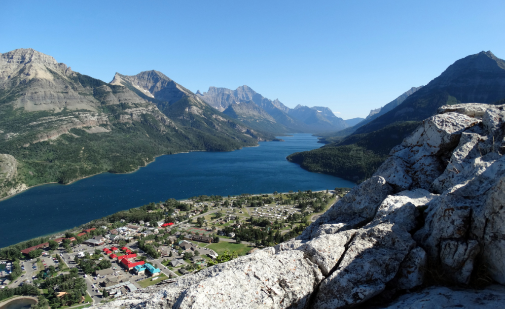 A town next to a lake with mountains all around, as seen from above.