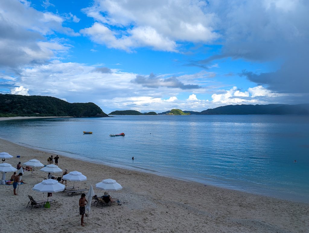 a beach with rain over the water