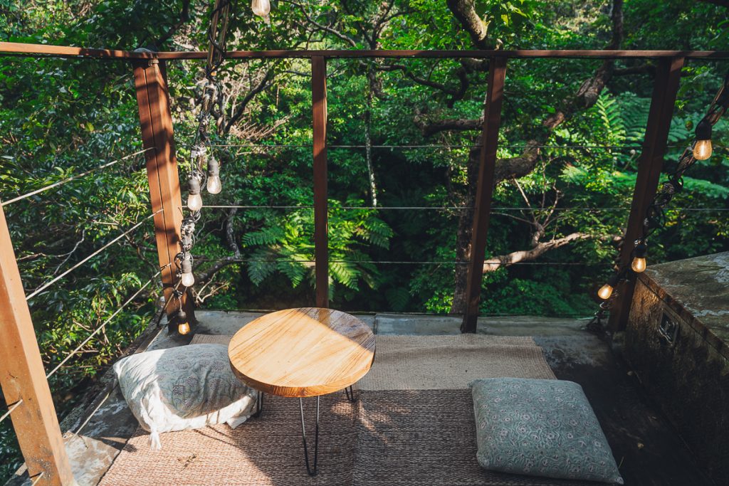 The top of a treehouse with cushions 