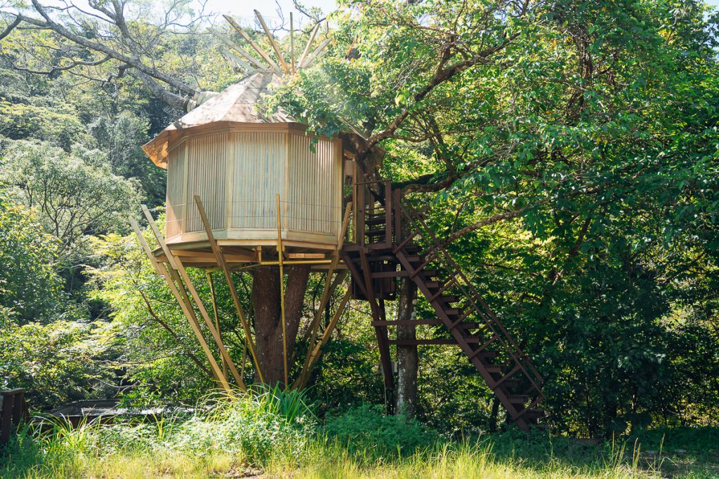 yurt-style treehouse suspended in the forest at Treeful Treehouse Okinawa