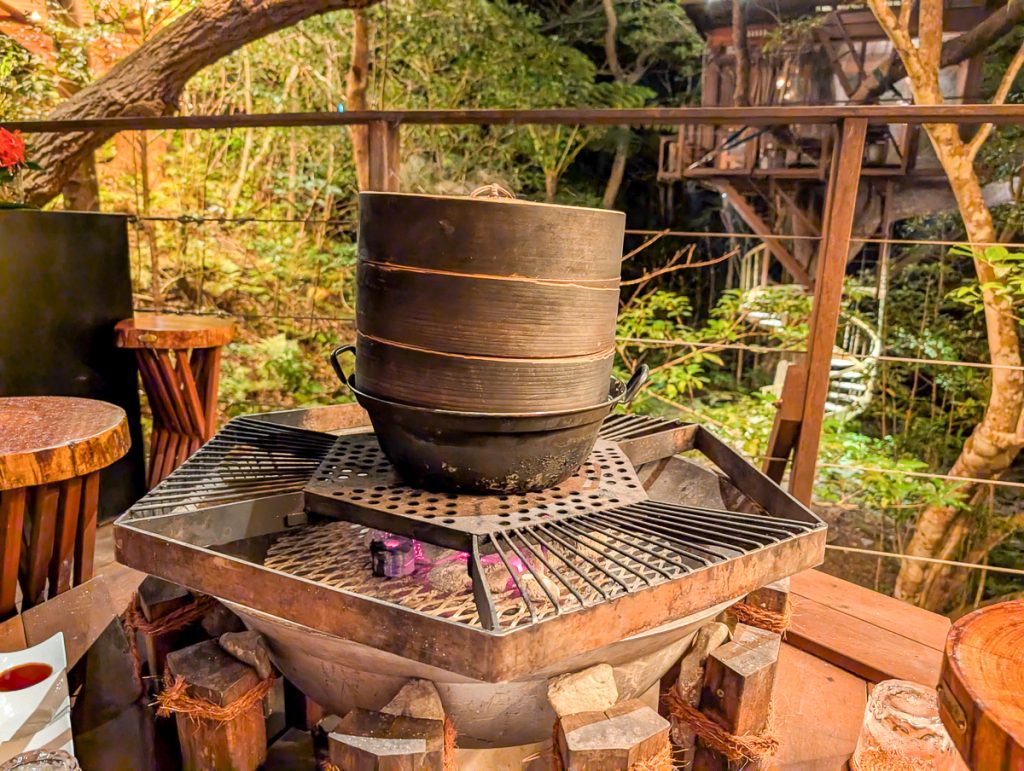a stack of bamboo steamer baskets sits on top of a BBQ