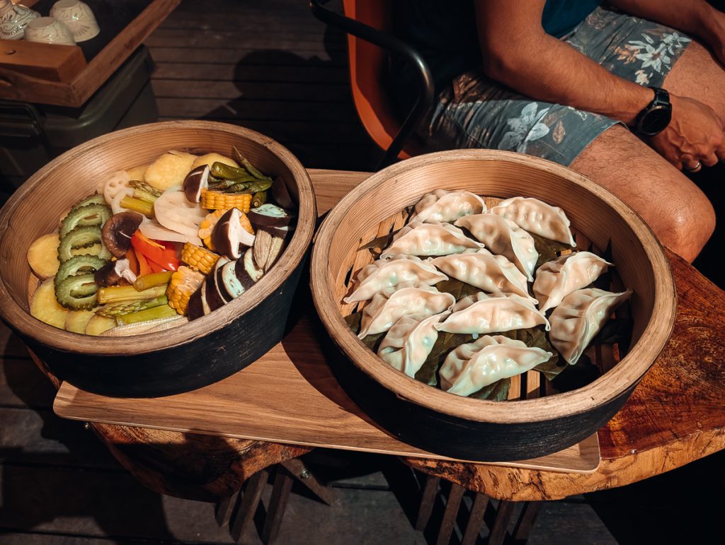 Two bamboo steamer posts full of vegan dishes
