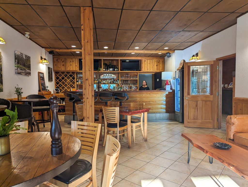 A small dining room with wooden furniture and a wooden bar in the back.