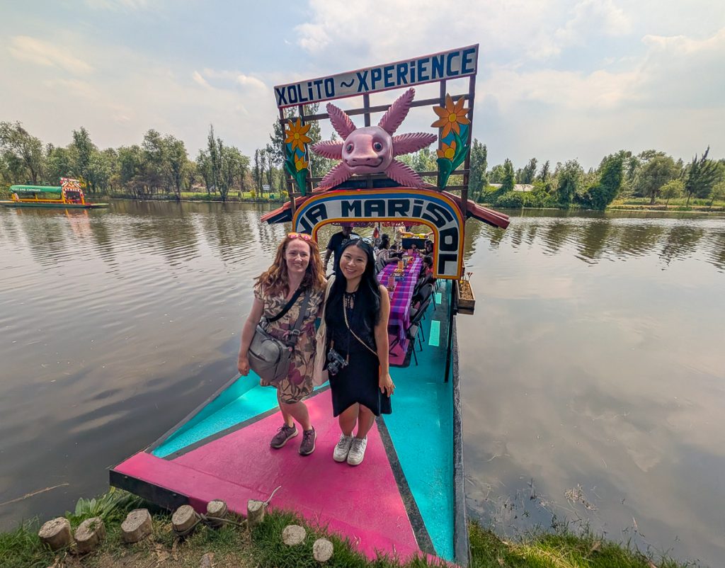 Sooz and Christina standing on a colorful traditional boat wearing dresses and comfy walking shoes.