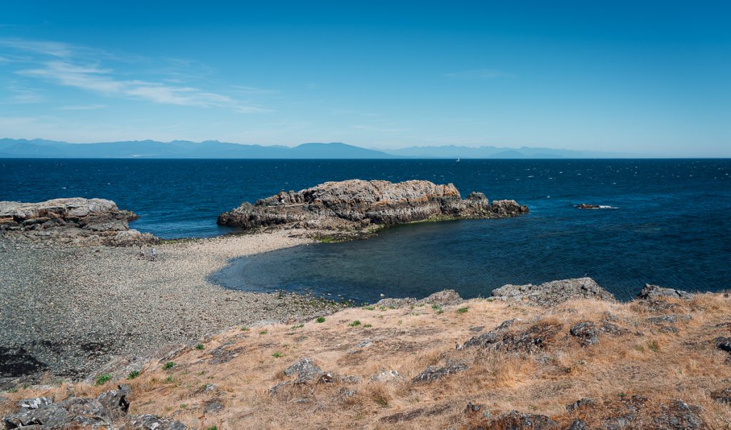 a sandy spit of land jutting out into deep blue water at Neck Point Park