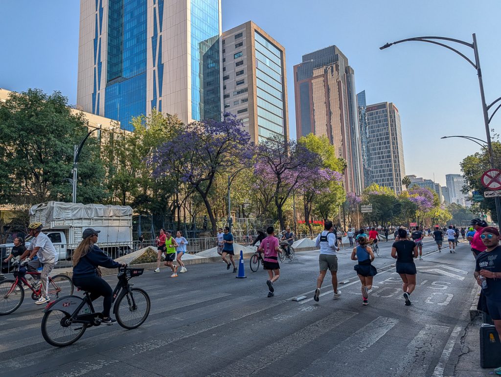 People walk and bike down a large street in Mexico City for car-free Sunday