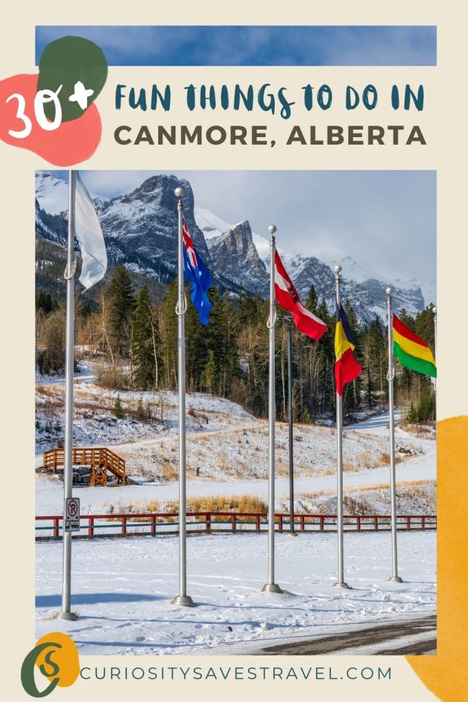 A photo of flagpoles with different country flags standing in snow with pine trees and mountains in the background. A text box on top of the image reads "30+ fun things to do in Canmore, Alberta."