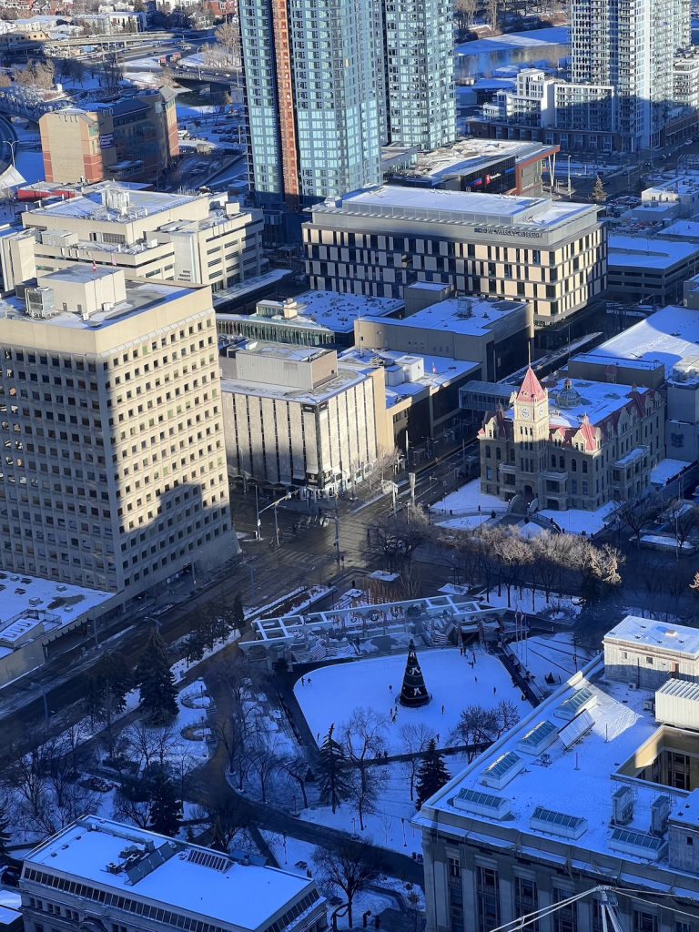 A view from Calgary Tower looking down over buildings and parks covered in snow.