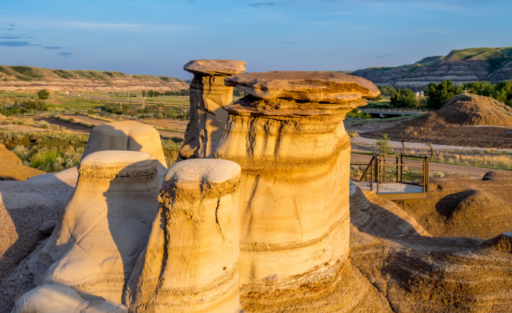 A group of sandstone rocks in strange shapes with a pathway next to them for visitors.