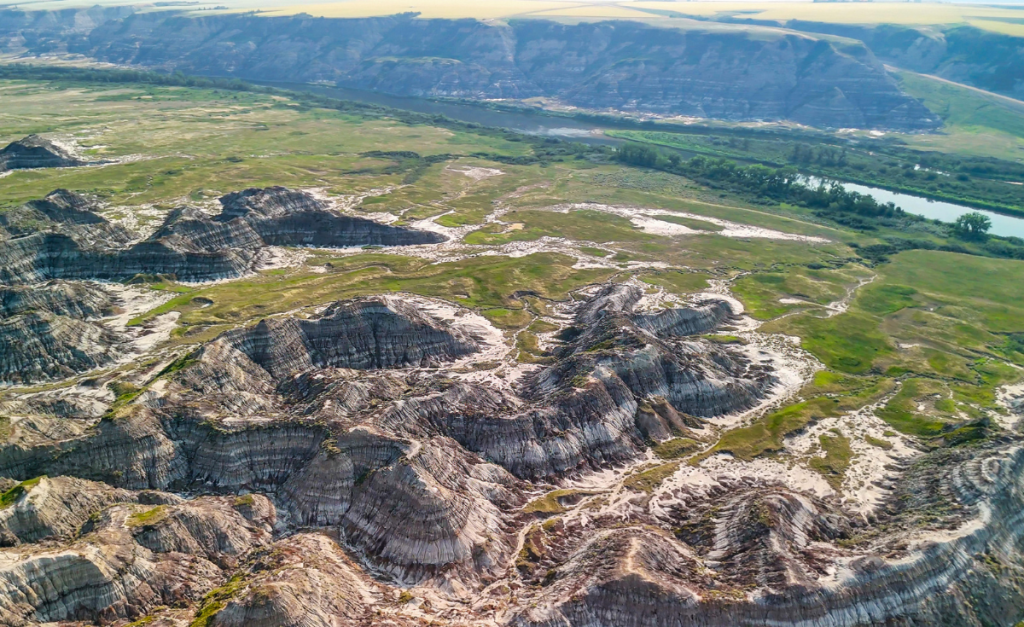 An aerial photo of mountains and valleys leading to a river.